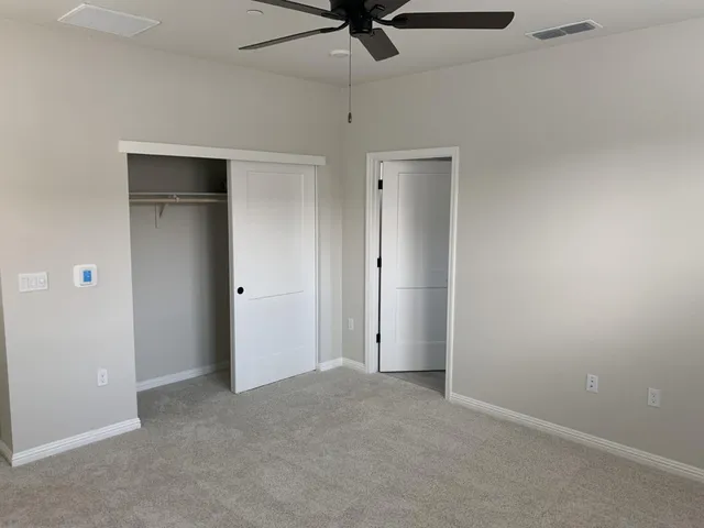 an empty room with a ceiling fan and entryway