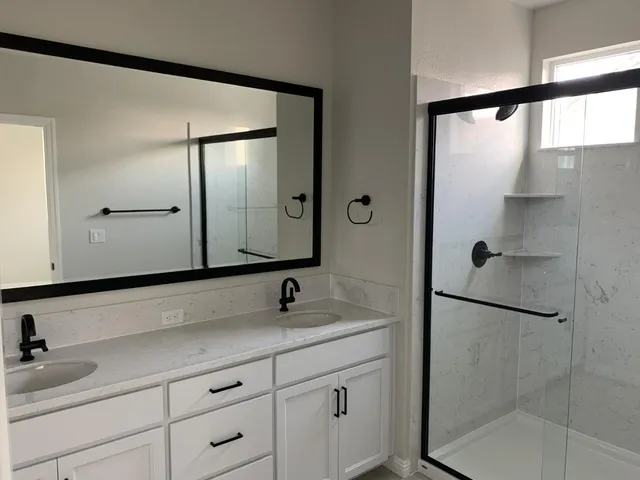 a bathroom with a shower sink and mirror