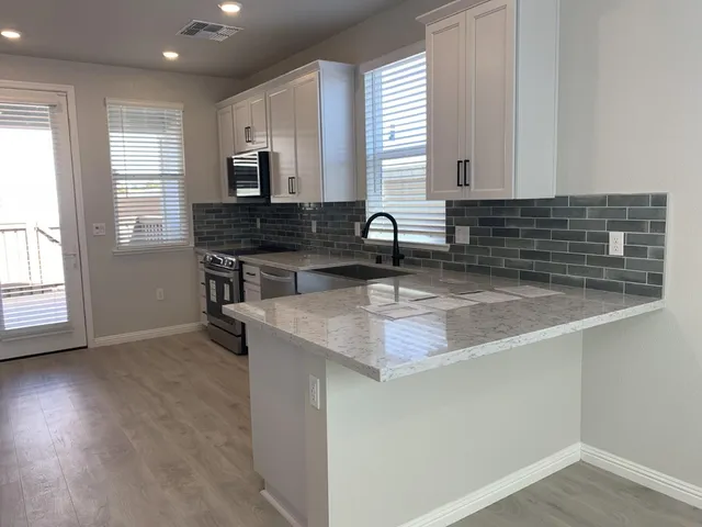 a kitchen with a sink stove and cabinets