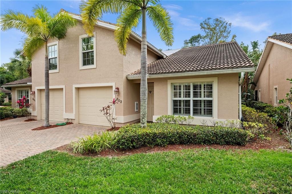 3520 Avion Woods Court, Unit 202 Naples, FL 34104 - Photo 1 of 26 a front view of a house with a yard