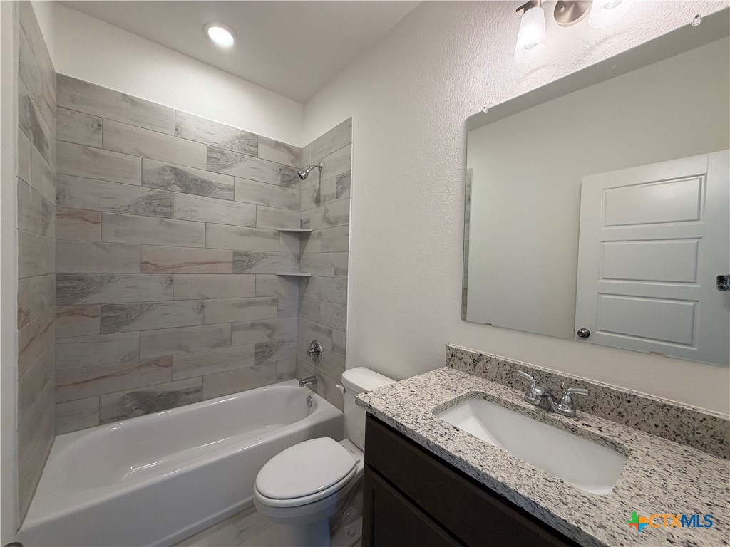 1985 Mercer Street Nolanville, TX 76559 - Photo 11 of 24 a bathroom with a granite countertop bathtub shower sink vanity mirror and toilet
