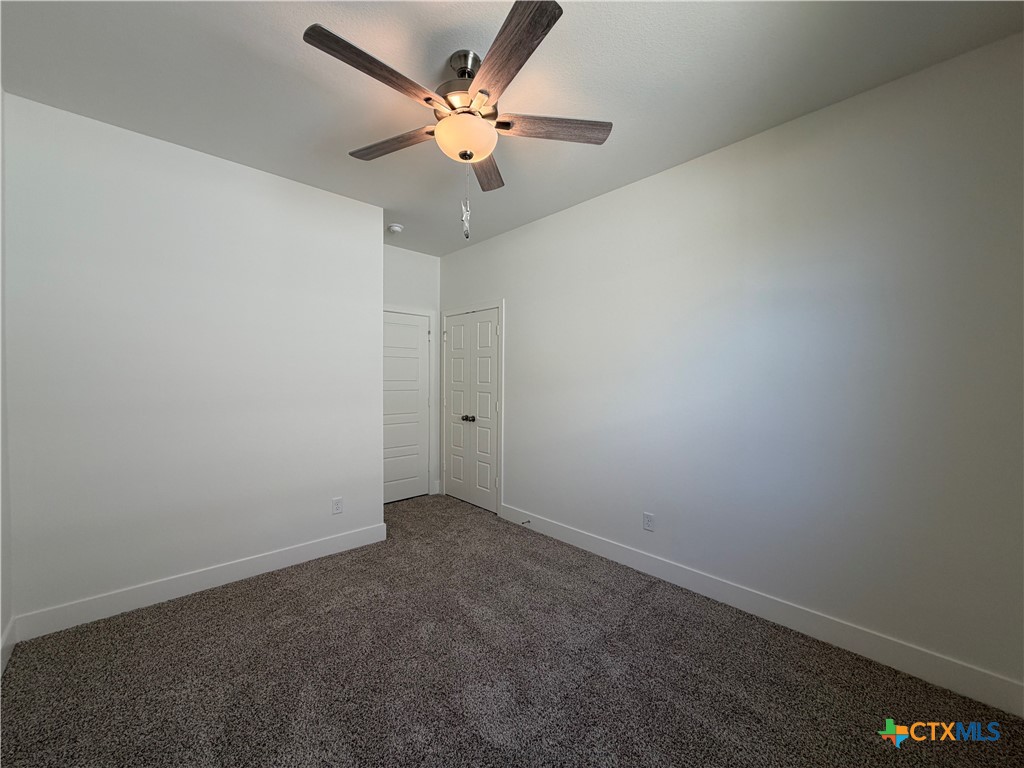 1985 Mercer Street Nolanville, TX 76559 - Photo 6 of 24 an empty room with a ceiling fan and wooden floor
