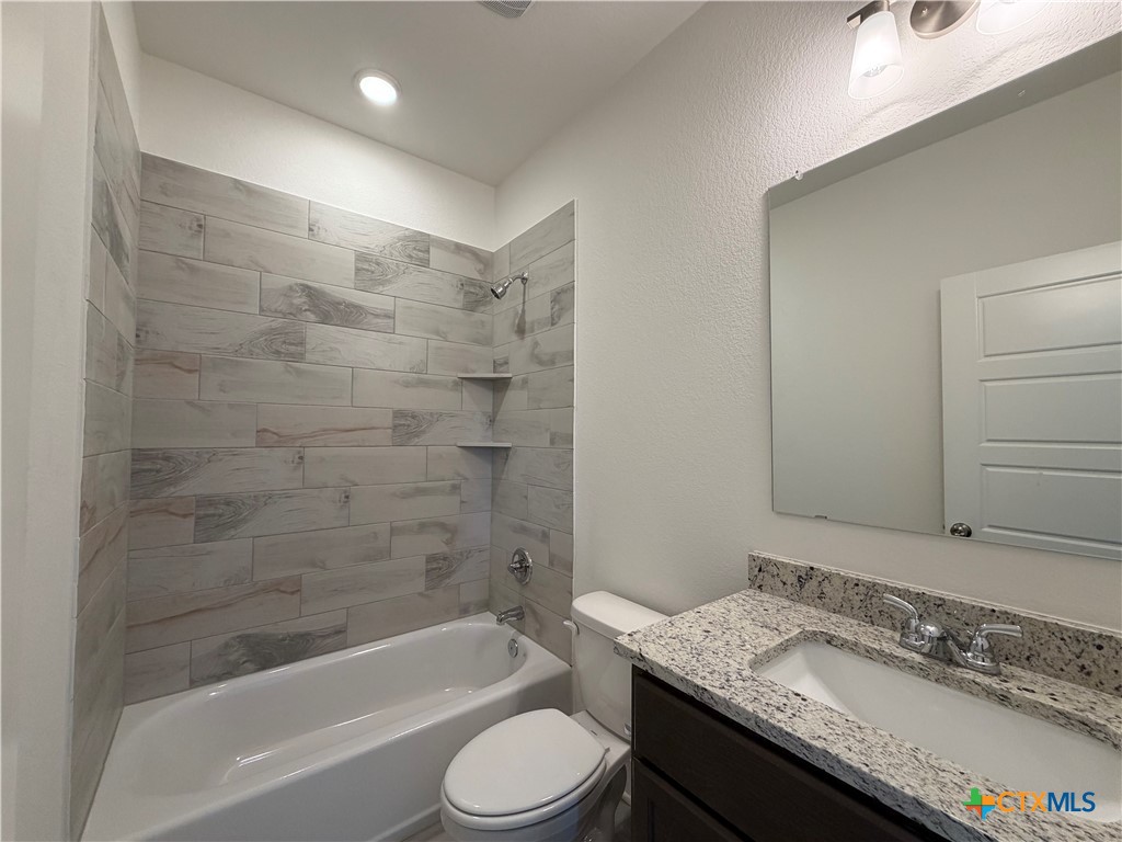 1985 Mercer Street Nolanville, TX 76559 - Photo 9 of 24 a bathroom with a granite countertop bathtub shower sink vanity mirror and toilet