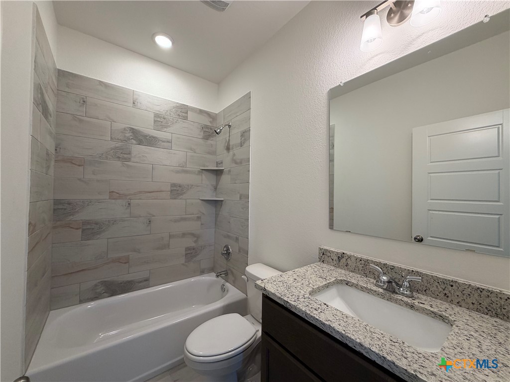 1985 Mercer Street Nolanville, TX 76559 - Photo 10 of 24 a bathroom with a granite countertop sink a toilet and bathtub