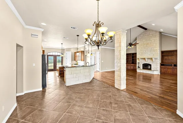 a kitchen with stainless steel appliances granite countertop a refrigerator a stove top oven and a sink with large cabinets