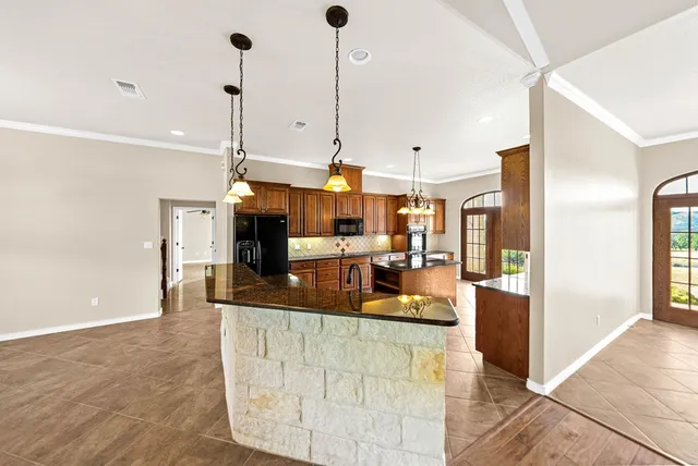 a kitchen with stainless steel appliances granite countertop a sink a counter top space appliances and a window