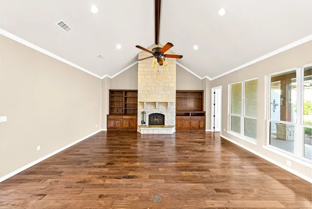 a view of empty room with wooden floor and fireplace