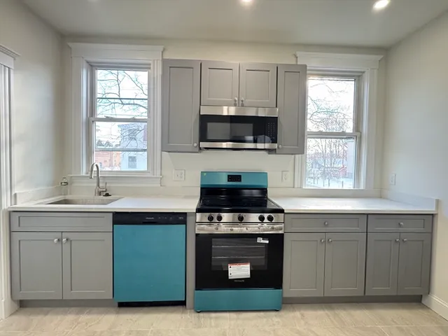 a kitchen with cabinets a window and stainless steel appliances