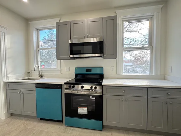 a kitchen with cabinets a window and stainless steel appliances