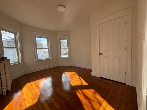 a view of empty room with wooden floor and windows