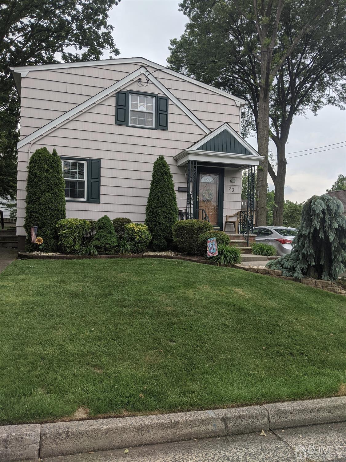 73 Highfield Road Colonia, NJ 07067 - Photo 2 of 16 a front view of a house with a yard