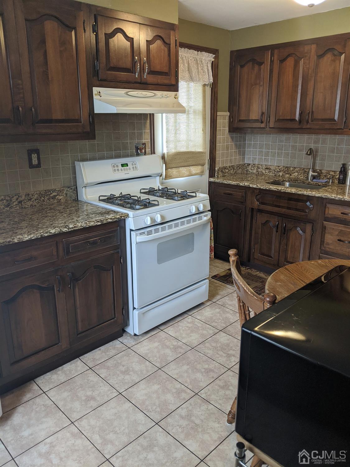 73 Highfield Road Colonia, NJ 07067 - Photo 4 of 16 a kitchen with stainless steel appliances granite countertop a stove a sink and a microwave