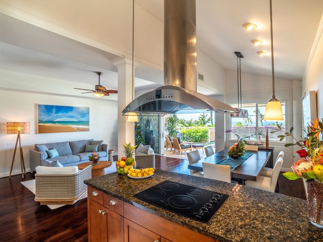 a kitchen with stainless steel appliances granite countertop a sink a stove and a wooden floor