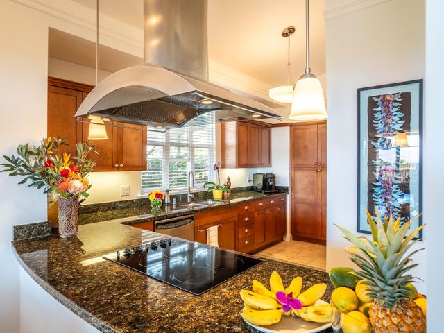 a kitchen with stainless steel appliances granite countertop a sink stove and cabinets