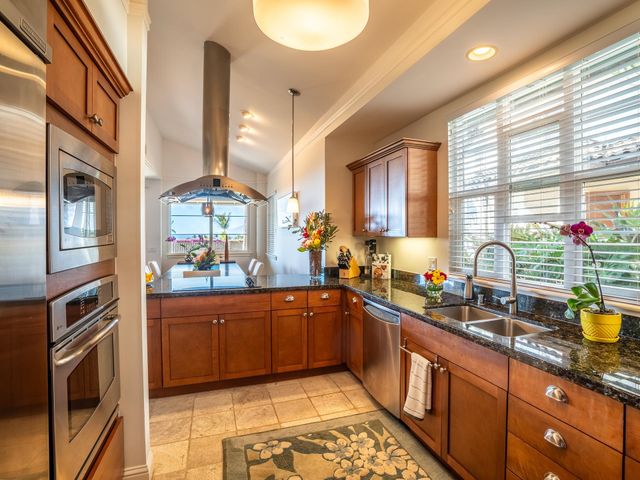 a kitchen with stainless steel appliances granite countertop a refrigerator and a stove
