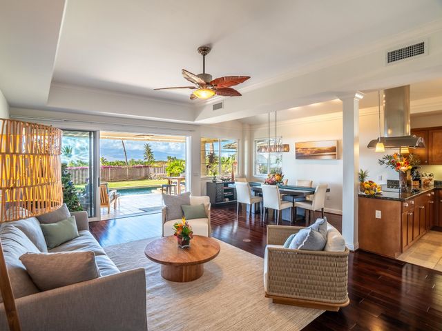a living room with furniture kitchen view and a chandelier