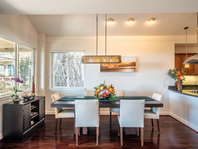 a dining room with furniture a chandelier and wooden floor