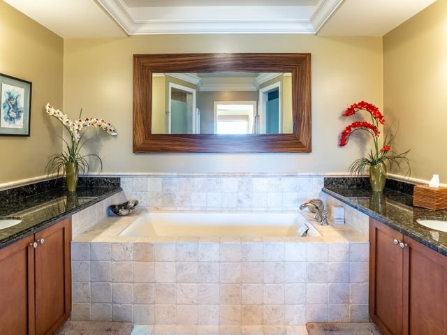 a en suite bathroom with a granite countertop sink and a mirror