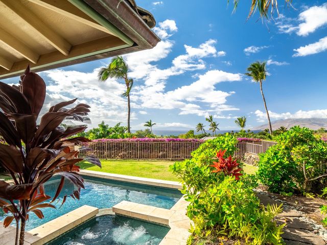 a view of a swimming pool with a yard and sitting area
