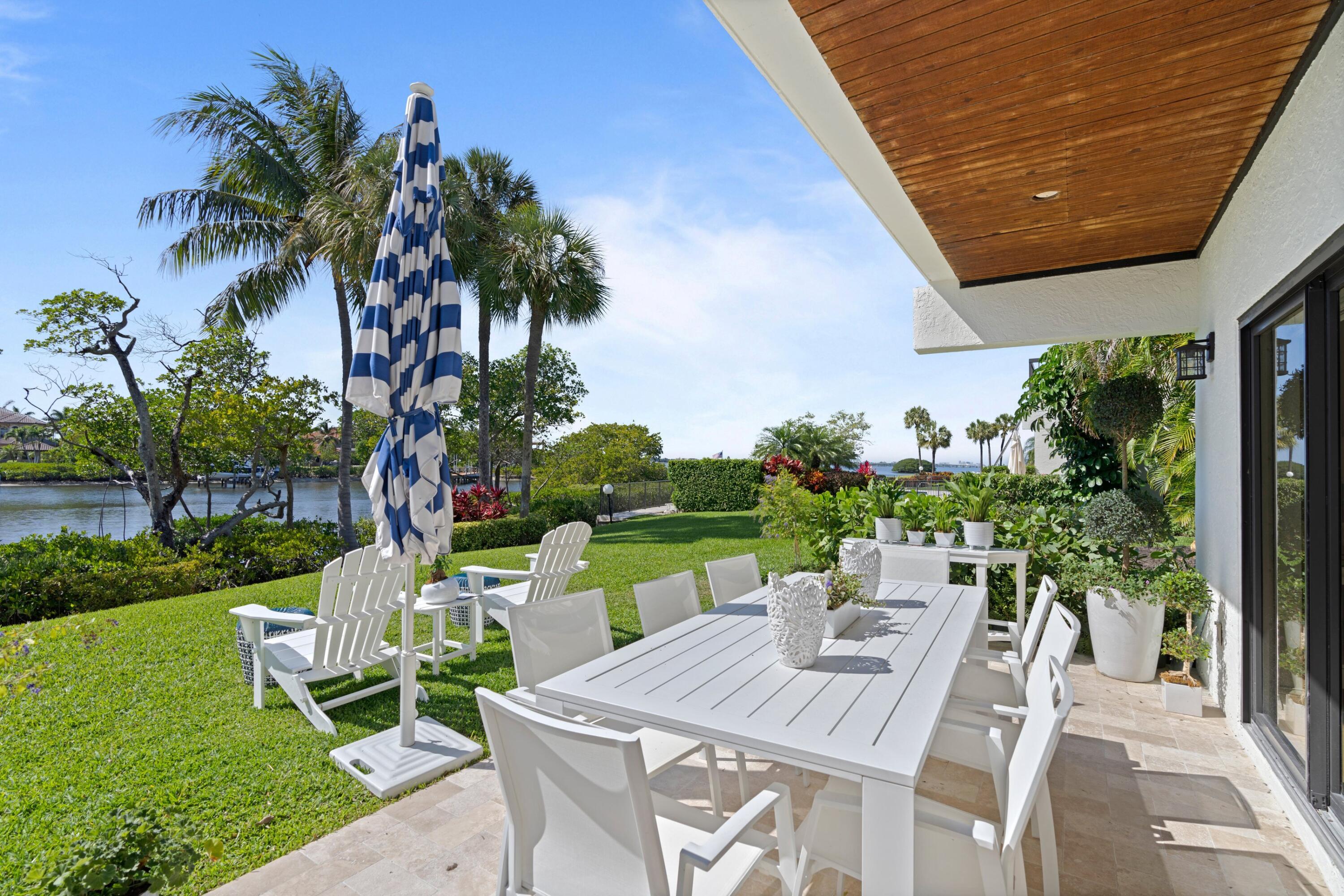 3474 South Ocean Boulevard, Unit 14 Palm Beach, FL 33480 - Photo 38 of 64 a view of a patio with table and chairs potted plants with palm trees