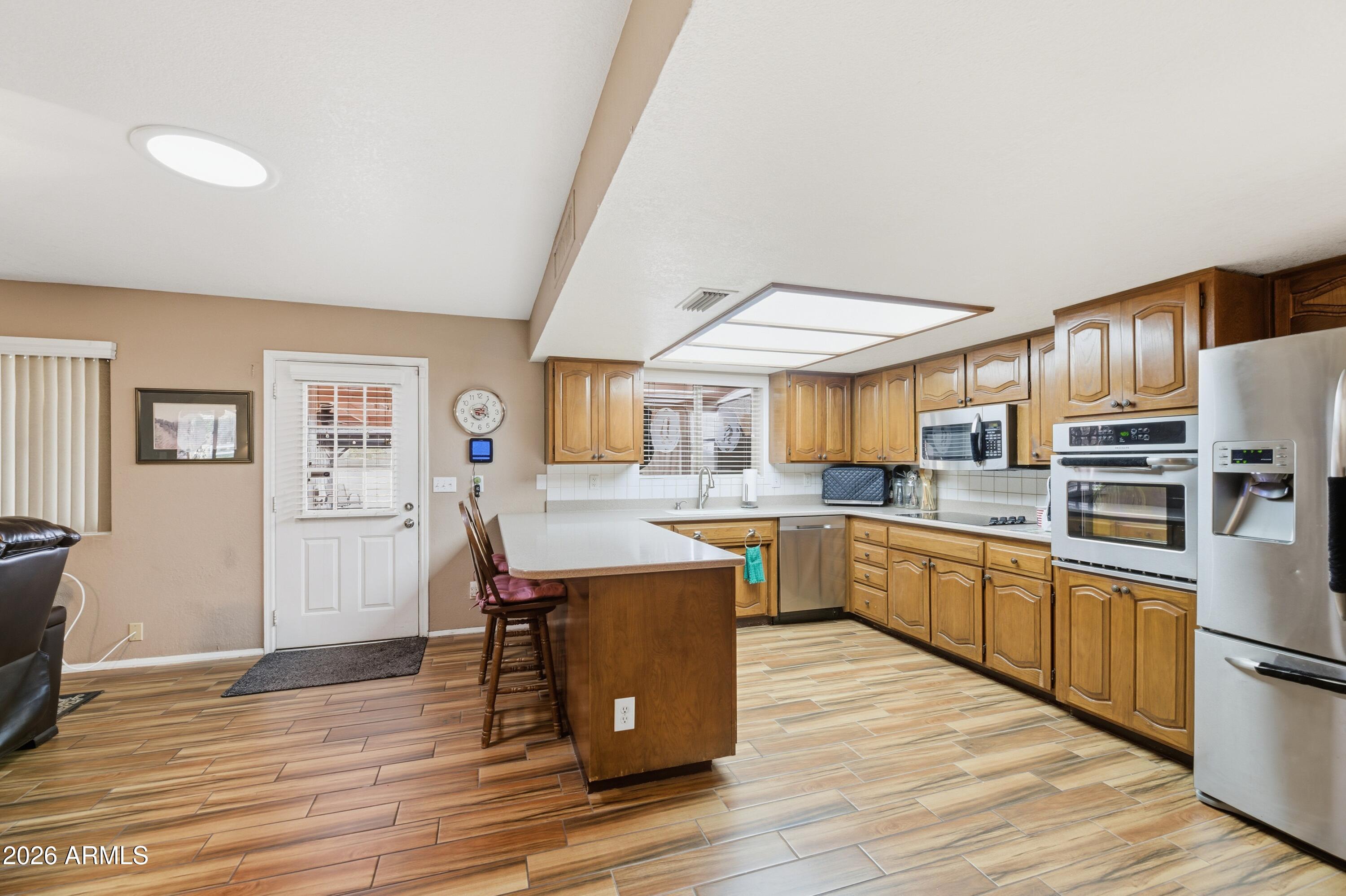 30 East Palo Verde Street Gilbert, AZ 85296 - Photo 6 of 38 a kitchen with stainless steel appliances granite countertop a refrigerator and stove top oven