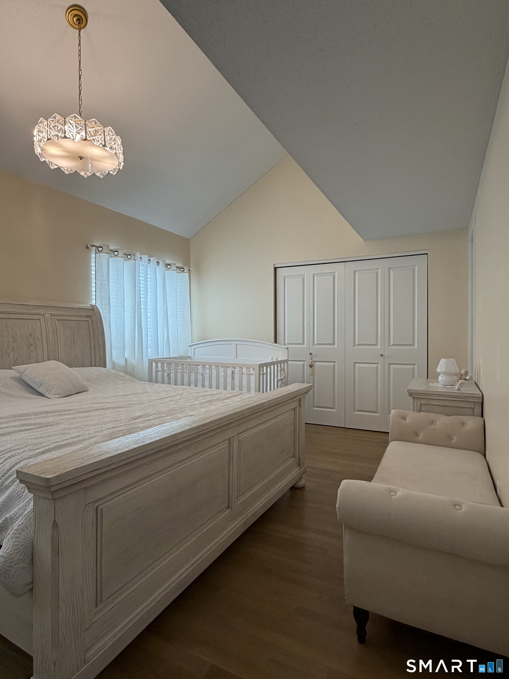 43 Sun Ridge Lane, Unit 43 Cromwell, CT 06416 - Photo 14 of 30 a spacious bedroom with a bed and a chandelier