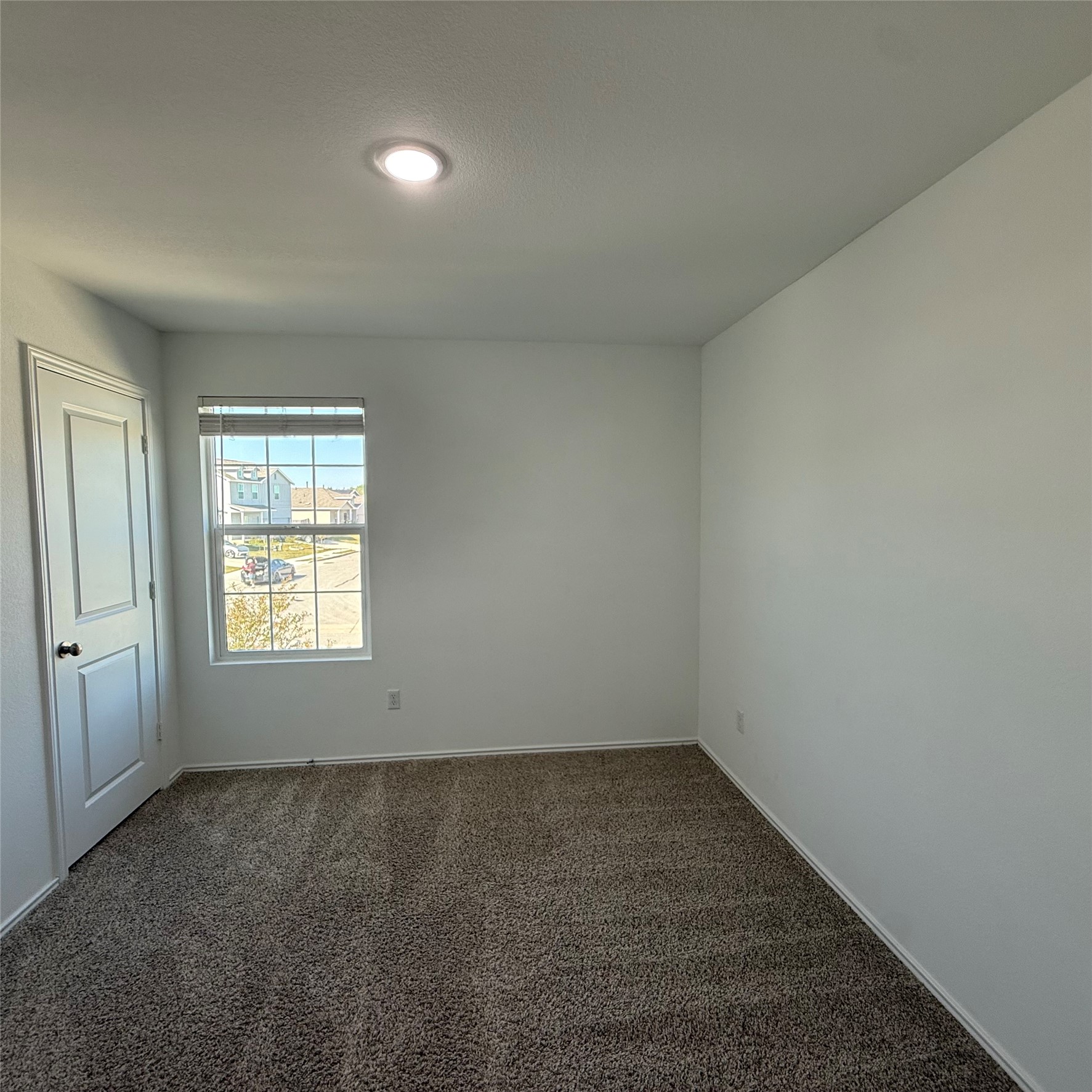 13711 Mussel Run Elgin, TX 78621 - Photo 27 of 31 Empty room with dark colored carpet and baseboards