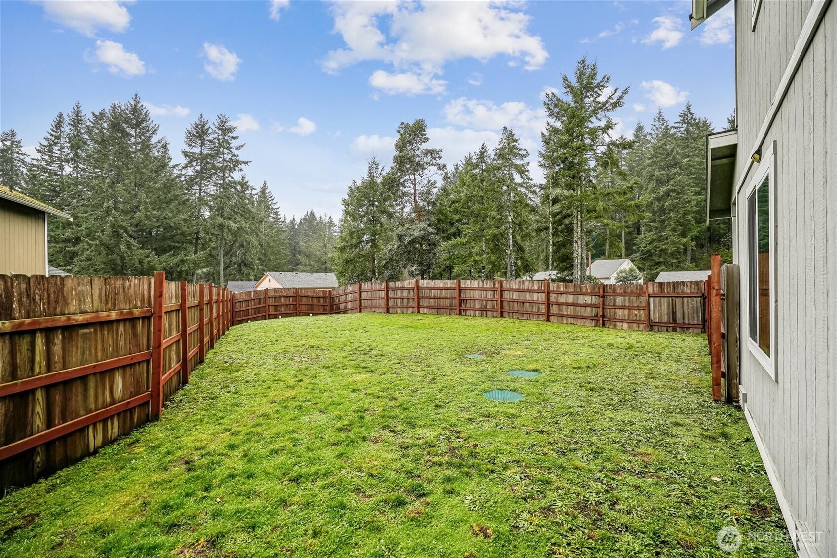 741 Northeast Larson Boulevard Belfair, WA 98528 - Photo 7 of 32 a view of a yard with a wooden fence