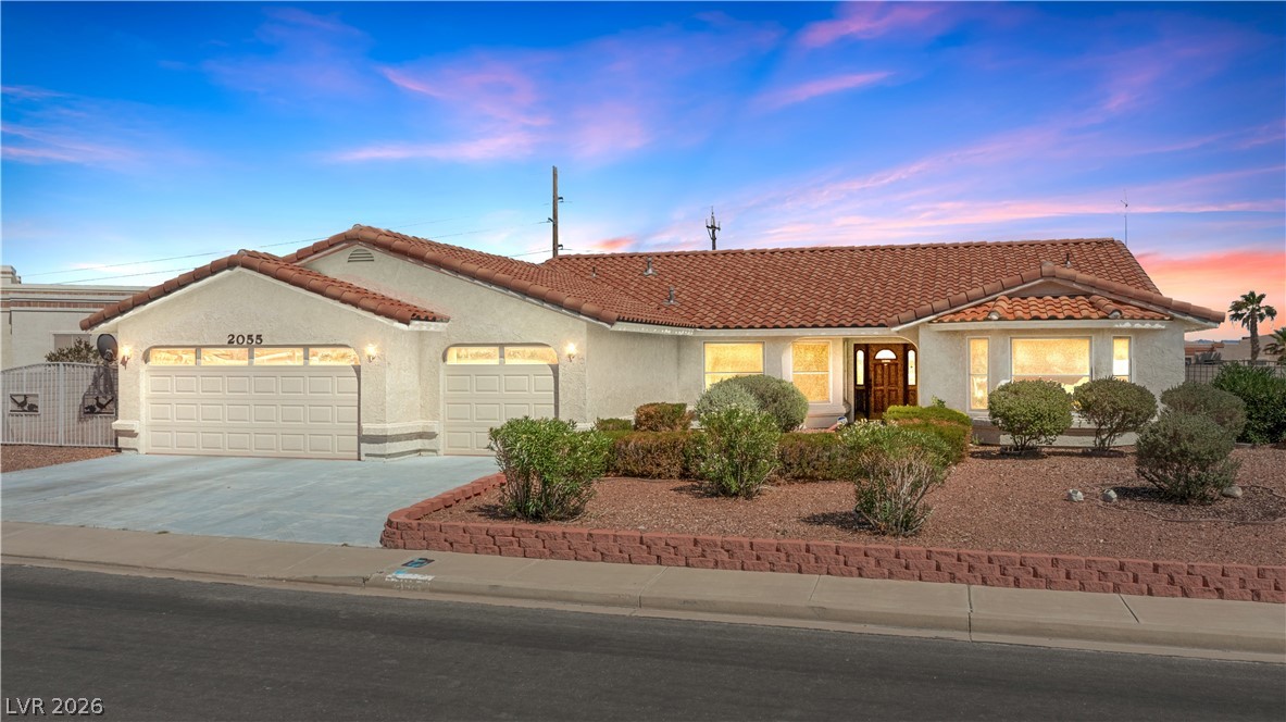A charming single-story residence boasts a classic tiled roof and well-maintained front landscaping.