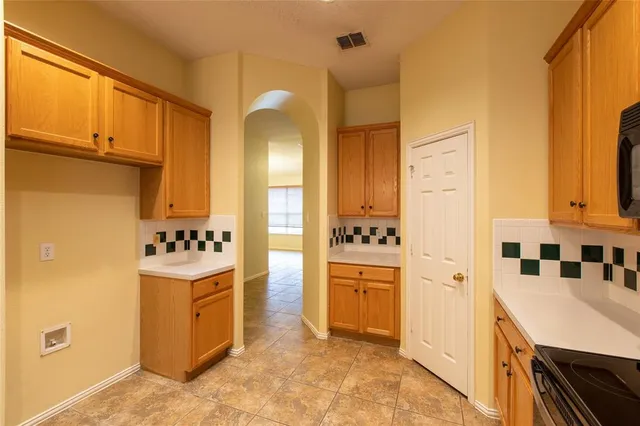 a kitchen with cabinets and refrigerator