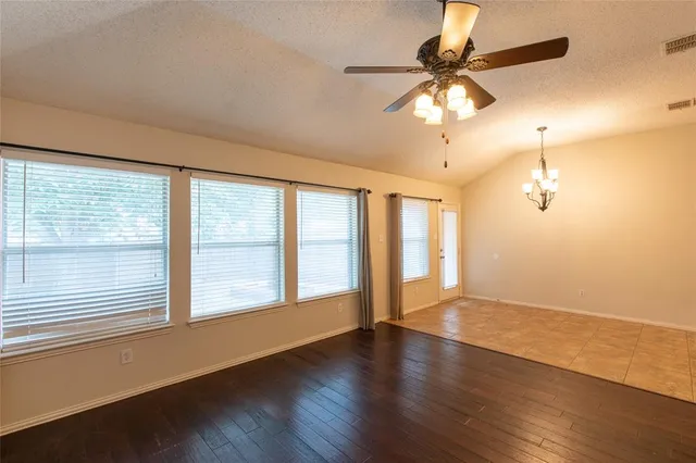 an empty room with a fireplace and wooden floor