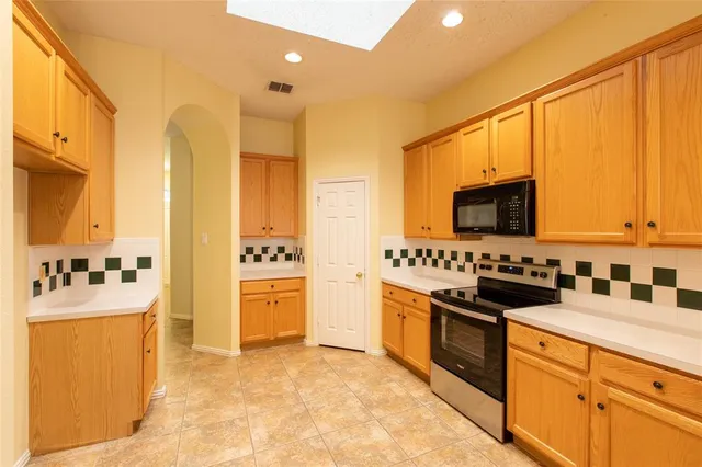 a kitchen with stainless steel appliances a stove sink and cabinets
