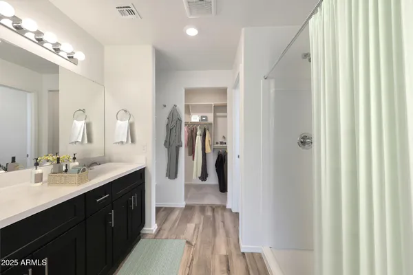 a en suite bathroom with a sink mirror and shower