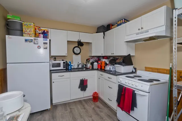 a kitchen with a refrigerator a stove and wooden cabinets