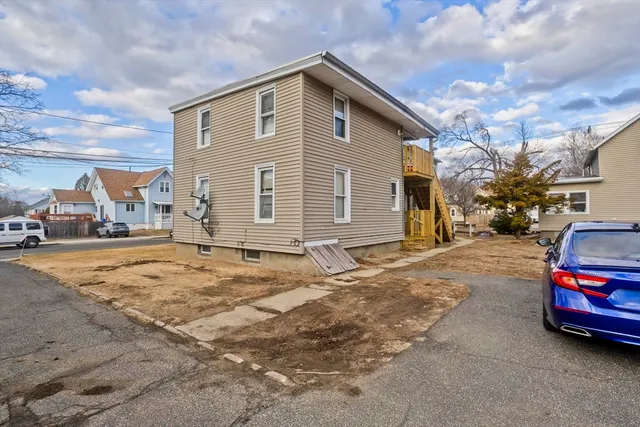 a view of a house with car parked on the road
