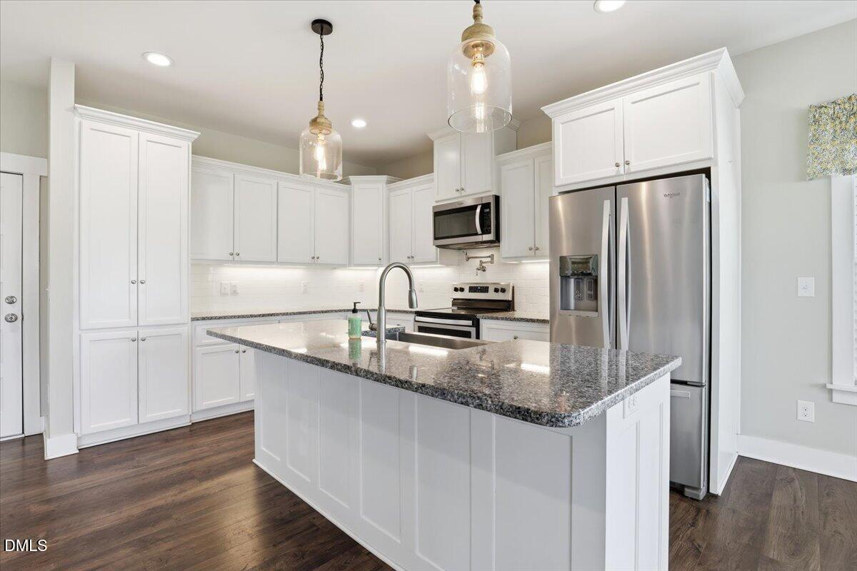 2249 Brogden Road Smithfield, NC 27577 - Photo 13 of 30 a kitchen with granite countertop a refrigerator a sink a center island and wooden floor