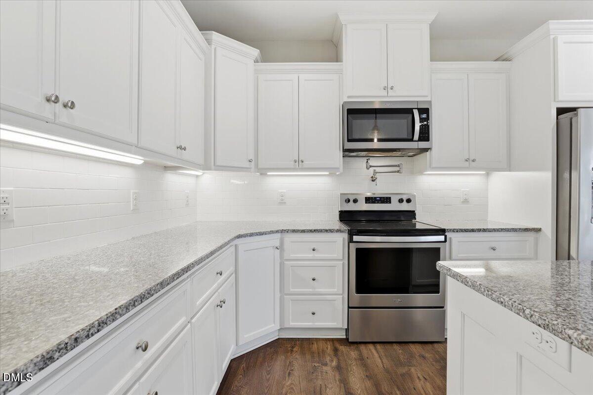2249 Brogden Road Smithfield, NC 27577 - Photo 15 of 30 a kitchen with granite countertop white cabinets and stainless steel appliances