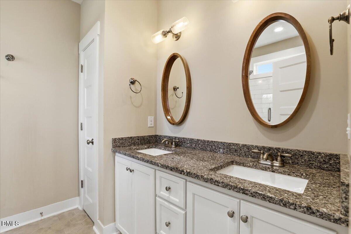 2249 Brogden Road Smithfield, NC 27577 - Photo 19 of 30 a bathroom with a granite countertop double vanity sink and a mirror