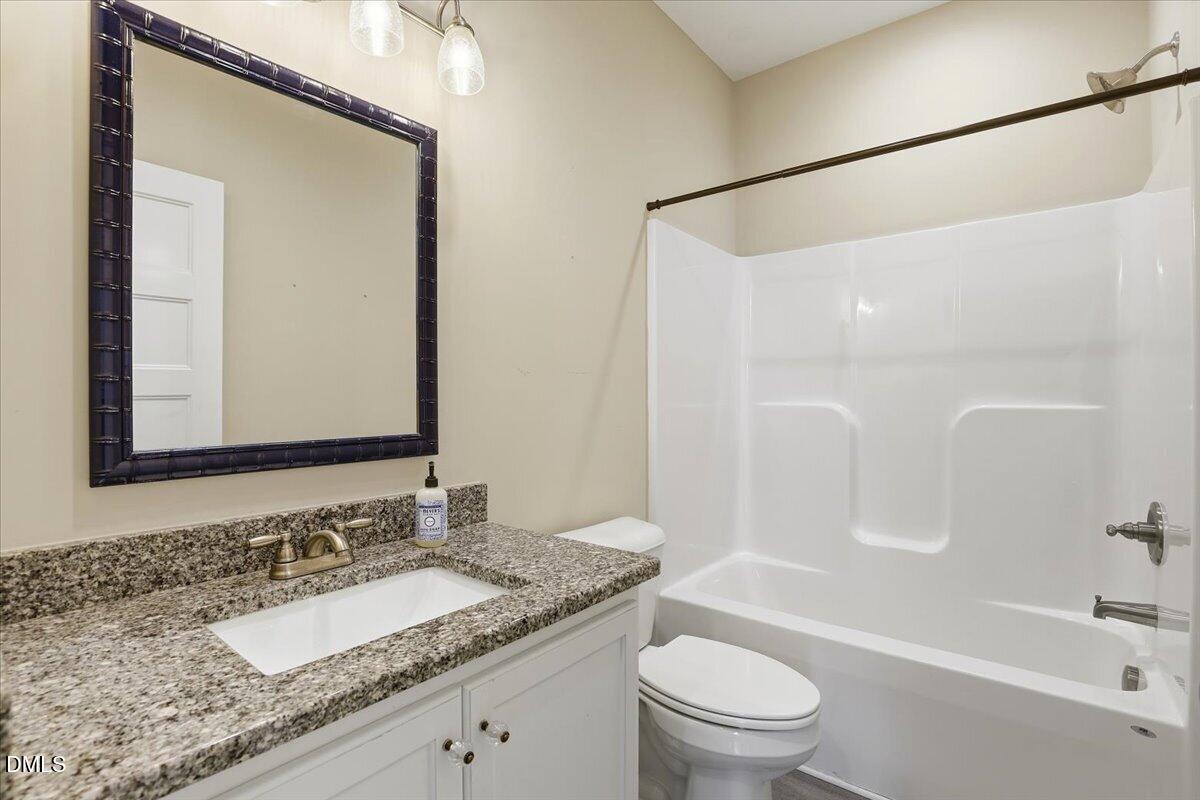 2249 Brogden Road Smithfield, NC 27577 - Photo 22 of 30 a bathroom with a granite countertop sink toilet and shower