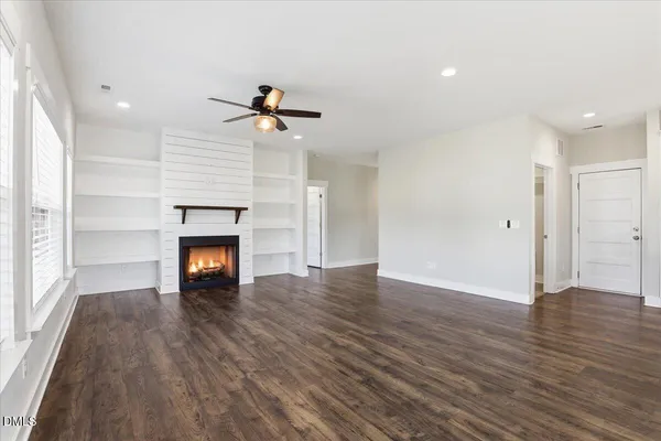 a view of empty room with wooden floor and fireplace