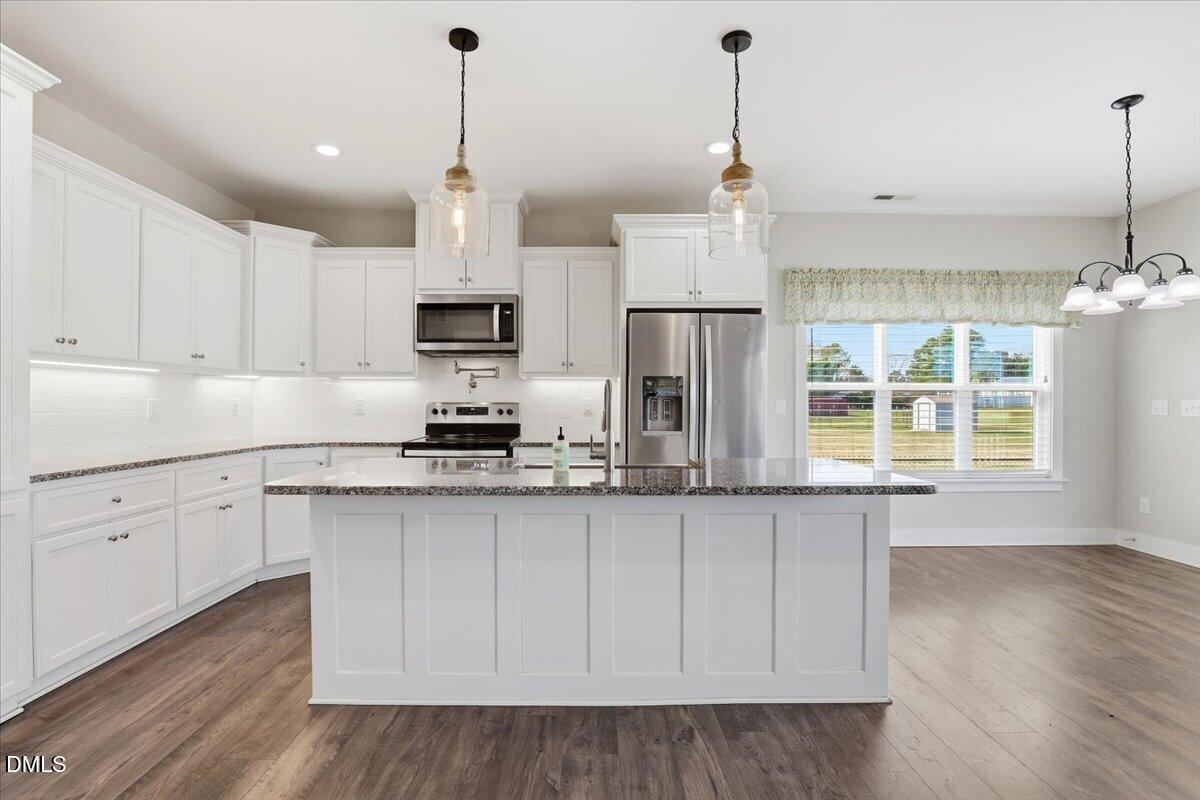 2249 Brogden Road Smithfield, NC 27577 - Photo 10 of 30 a kitchen with stainless steel appliances granite countertop a refrigerator a sink dishwasher a stove and white cabinets with wooden floor