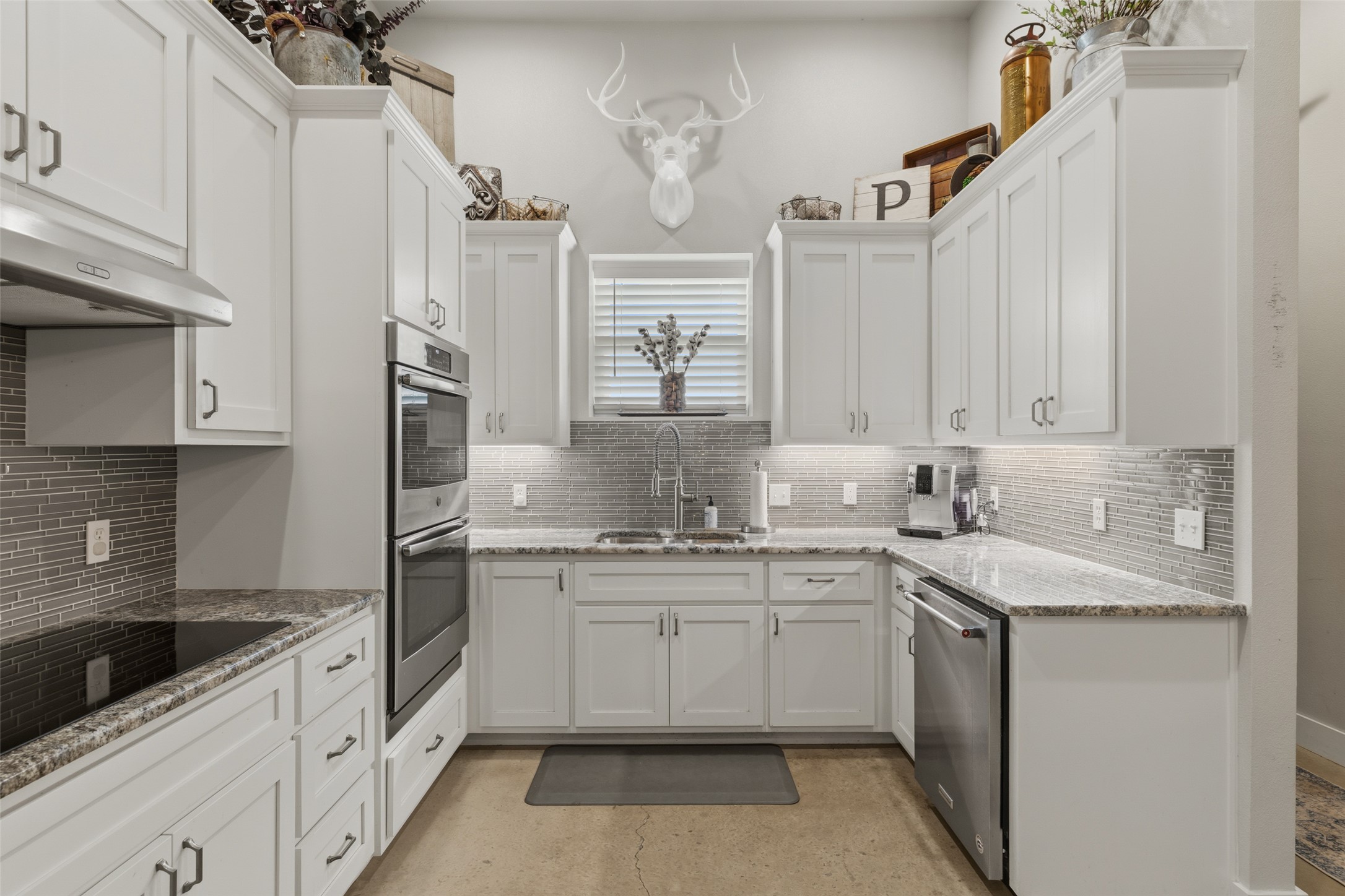 764 Stubbs Road Johnson City, TX 78636 - Photo 15 of 29 A well-appointed kitchen showcasing elegant white cabinetry and stainless steel appliances.