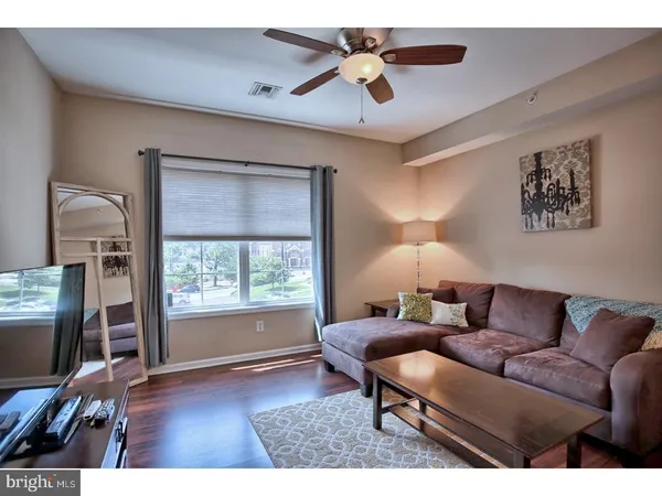 a living room with furniture a flat screen tv and a window