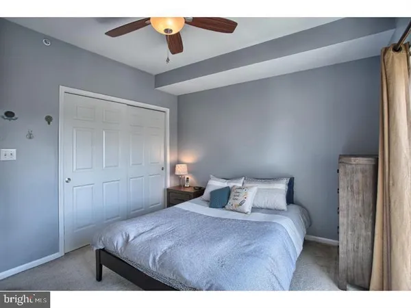 a bedroom with a bed and a ceiling fan