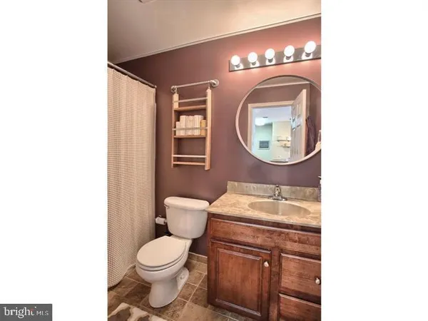 a bathroom with a toilet sink vanity and mirror
