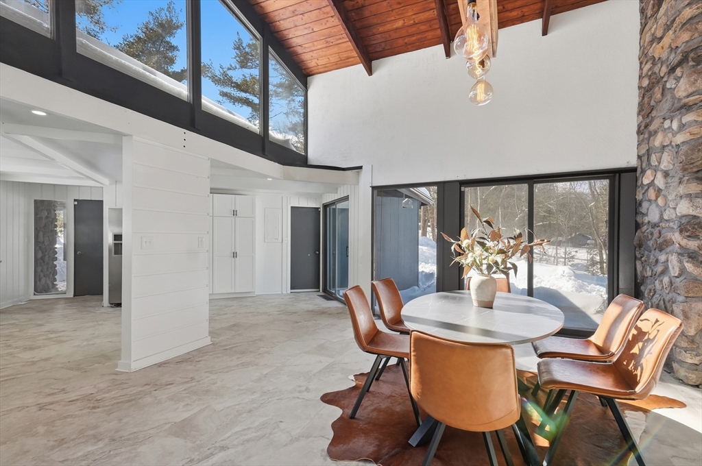 1081 Lowell Road Groton, MA 01450 - Photo 11 of 42 a dining room with furniture a rug and a large window