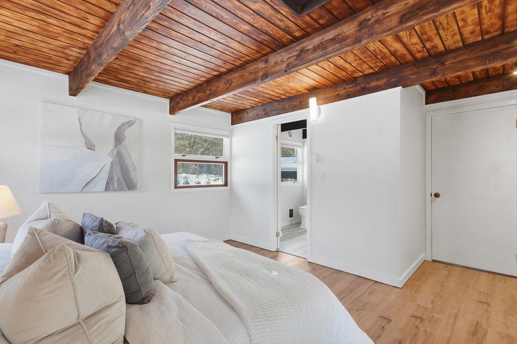 1081 Lowell Road Groton, MA 01450 - Photo 18 of 42 a bedroom with a bed and a wooden floor