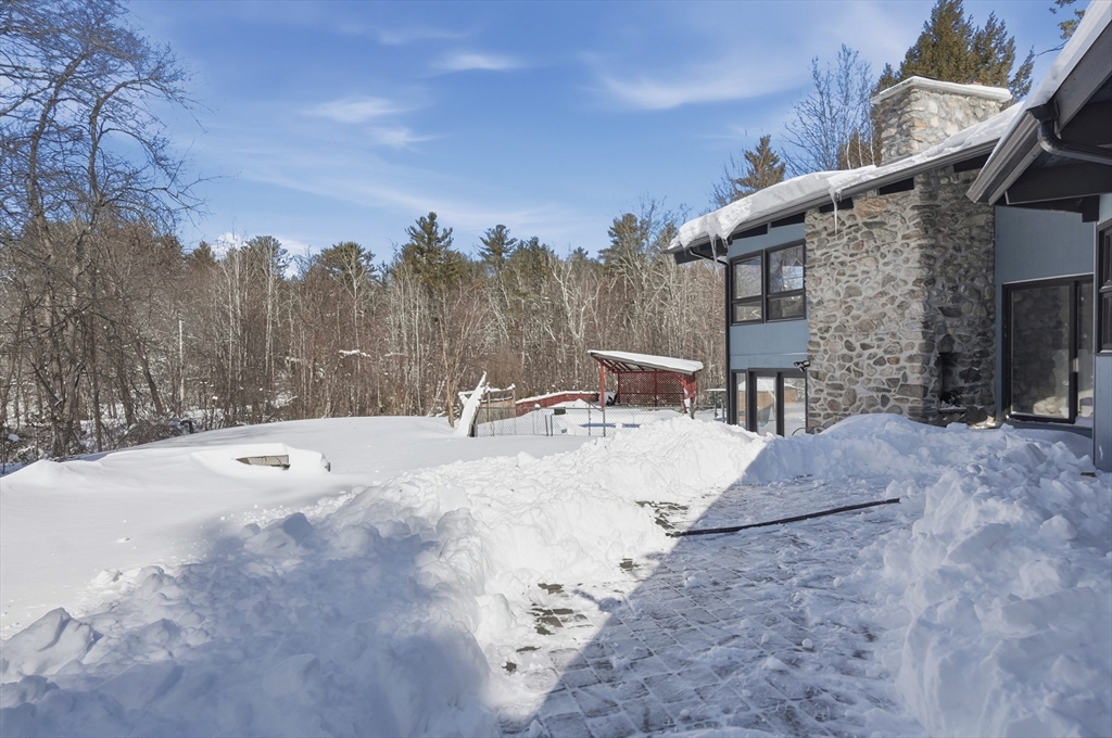1081 Lowell Road Groton, MA 01450 - Photo 36 of 42 a view of a backyard with snow on the road