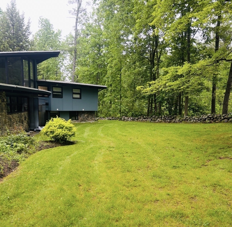 1081 Lowell Road Groton, MA 01450 - Photo 41 of 42 a view of a garden with a bench