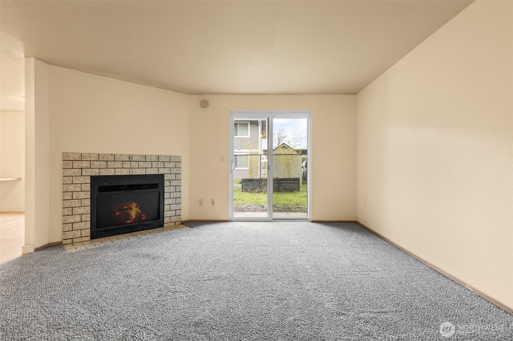 15912 Elm Street East Sumner, WA 98390 - Photo 11 of 30 a view of an empty room with a fireplace and a window